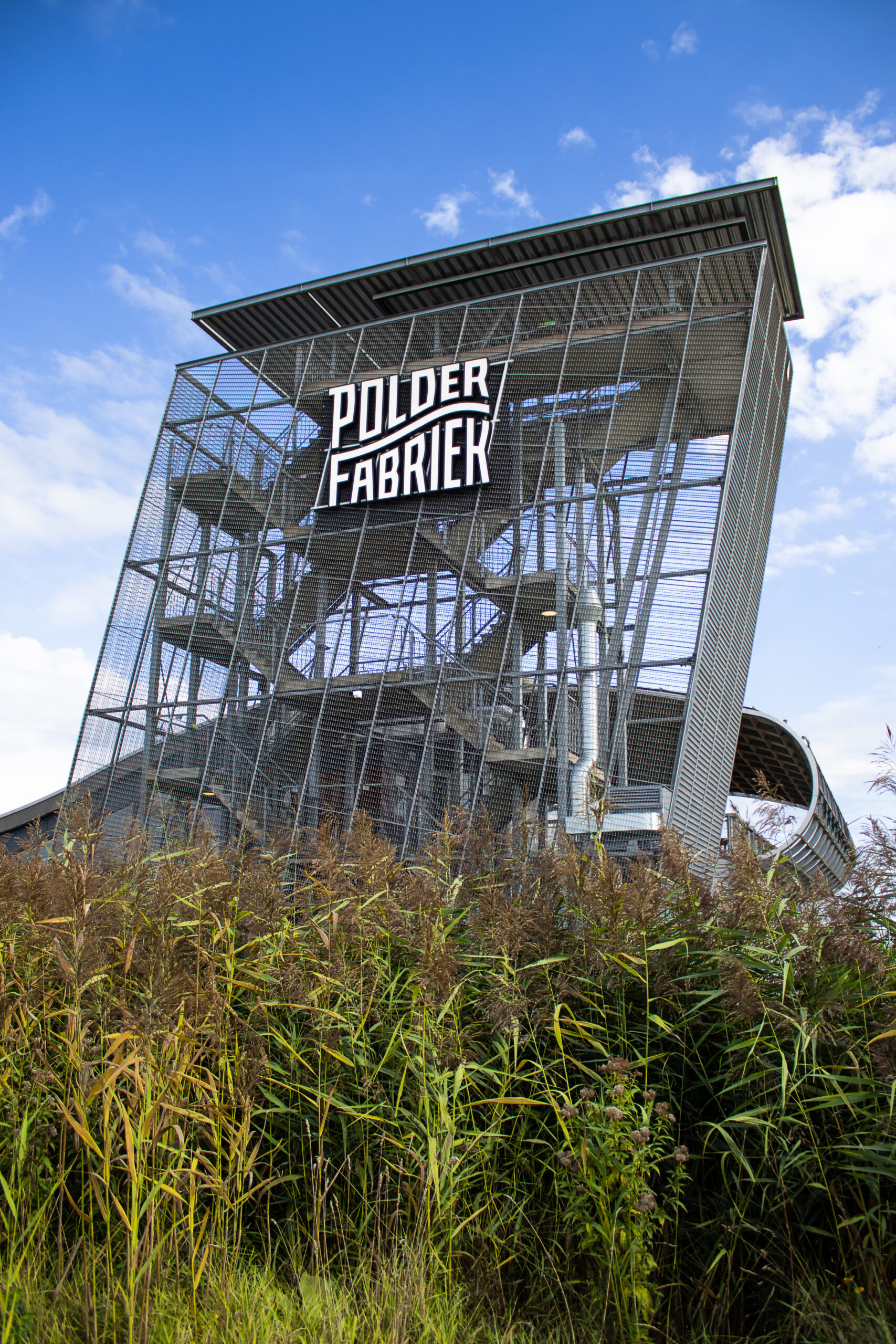 Uitkijktoren van Brasserie Polderfabriek met het logo, tussen het riet