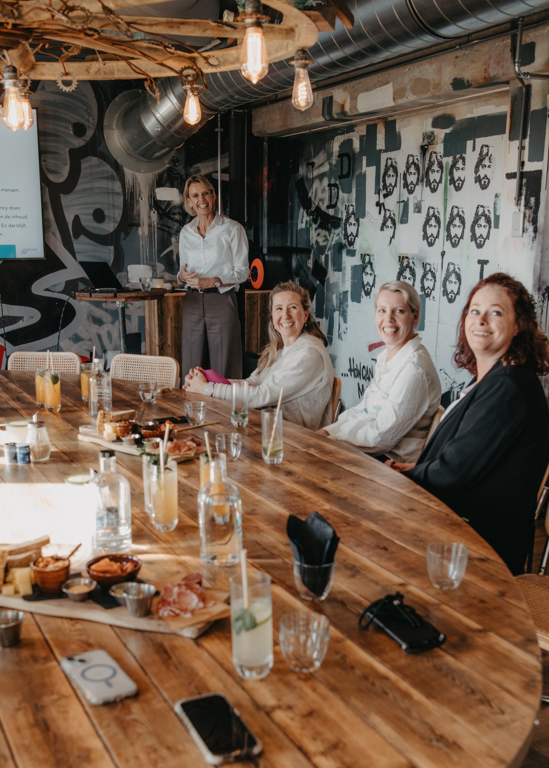 Presentatie voor een groep aan een lange houten tafel in een zaal van Brasserie Polderfabriek